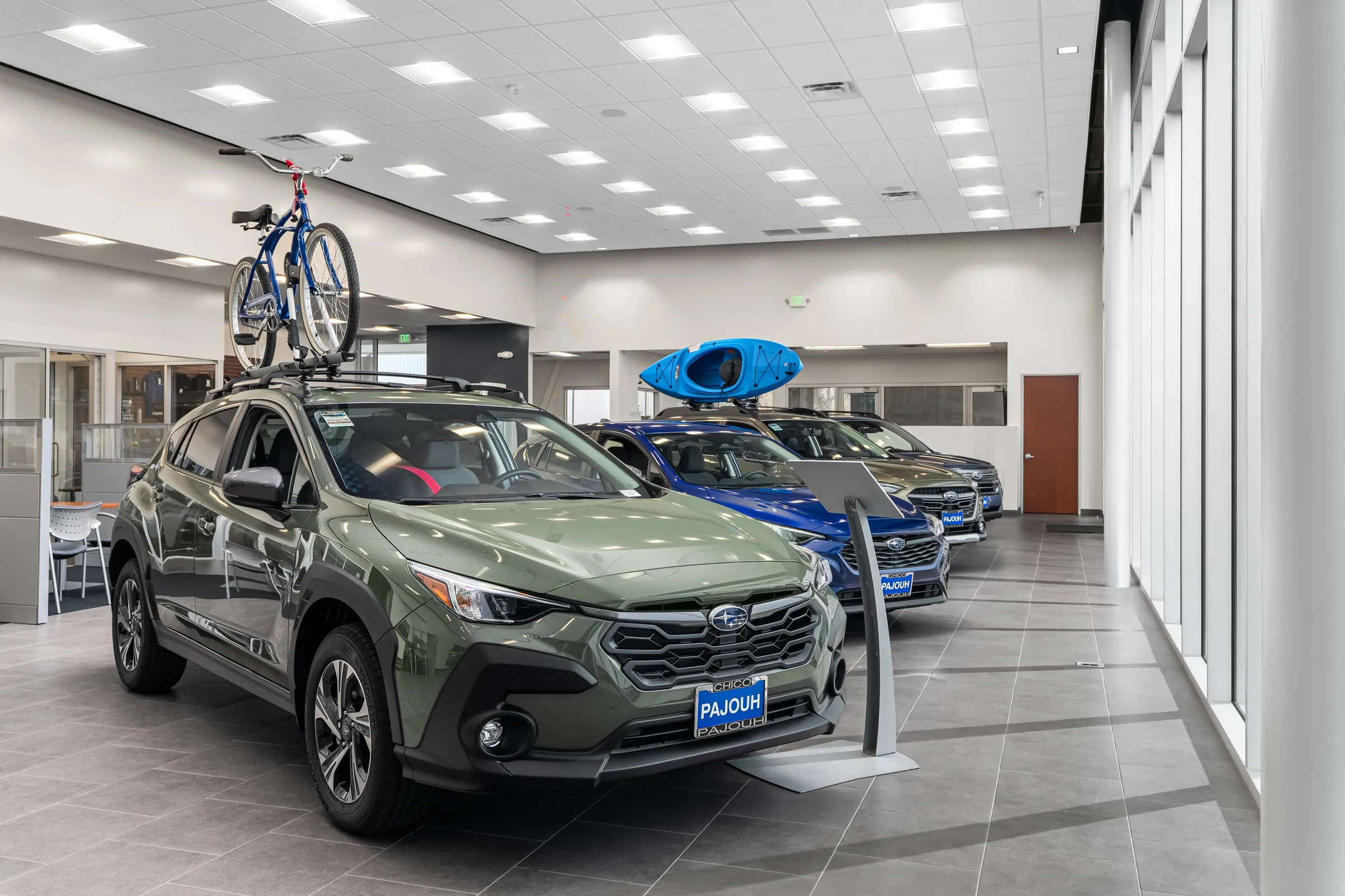 Automotive dealership exteriors at dusk and the showroom interiors behind them. Frame 6 of 6.
